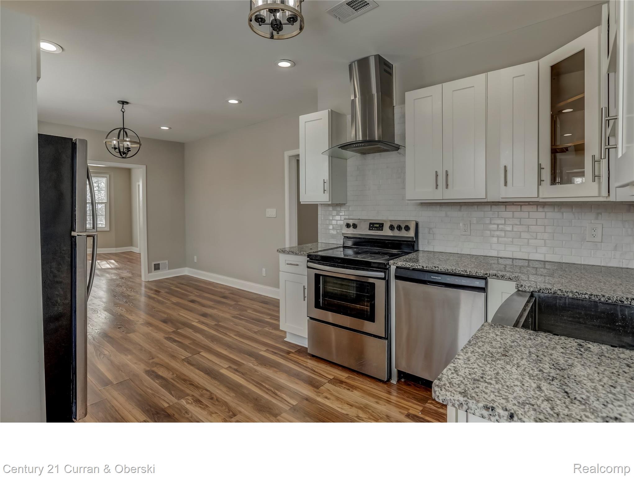 641 Josephine Street Detroit, MI 48202 - Photo 5 of 11 Kitchen featuring white cabinetry, stainless steel appliances, speckled countertops, and a subway tile backsplash