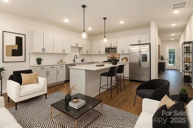 a kitchen with stainless steel appliances kitchen island granite countertop a refrigerator a stove a sink dishwasher a dining table and chairs with wooden floor