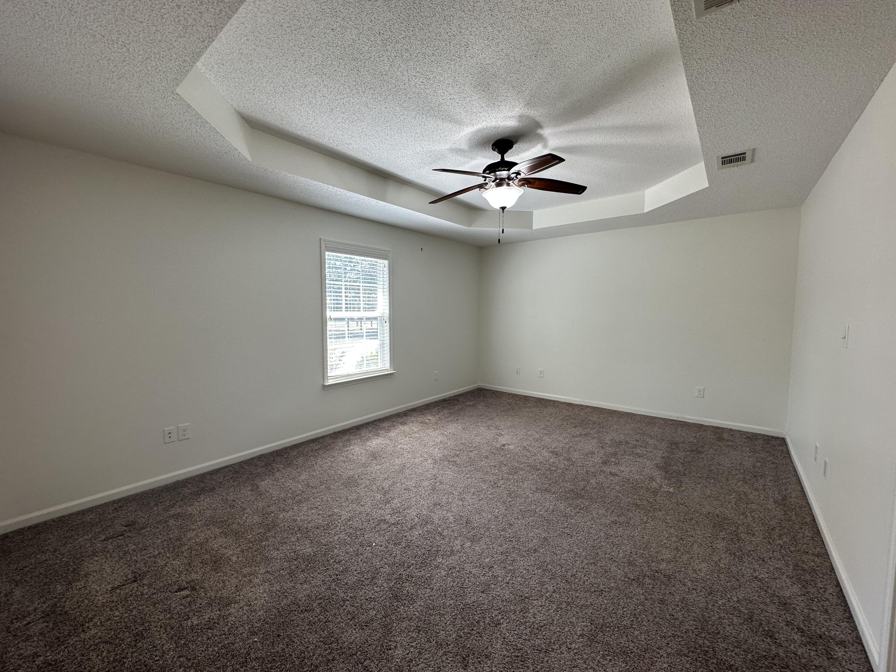 5570 Mt Olive Road Crestview, FL 32539 - Photo 15 of 34 an empty room with a chandelier fan and windows