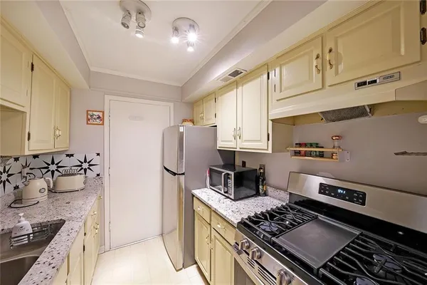 a kitchen with stainless steel appliances granite countertop a stove and a refrigerator