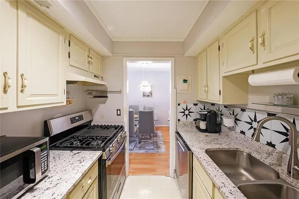 a kitchen with sink a stove and cabinets