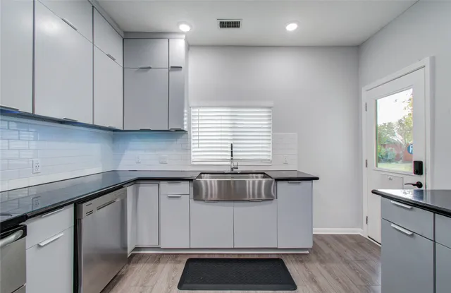 a kitchen with kitchen island granite countertop a sink cabinets and window