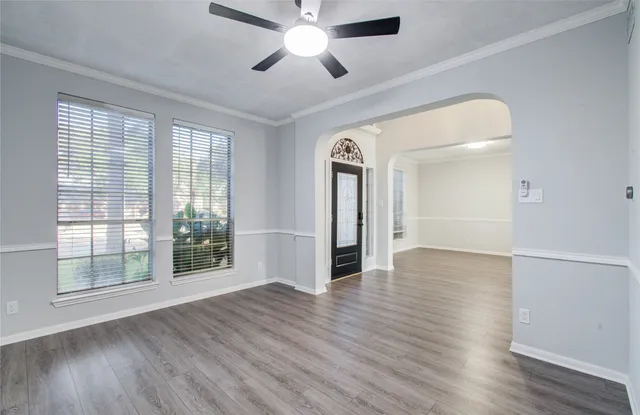 a view of empty room with wooden floor and fan