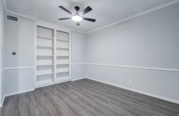 a view of a room with wooden floor and a ceiling fan