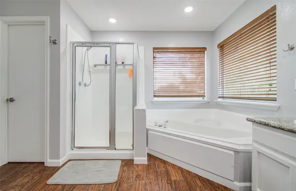 a bathroom with a granite countertop tub shower and sink