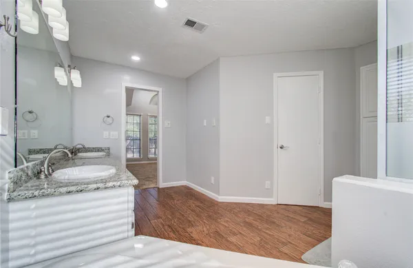 a spacious bedroom with a bed and a dresser