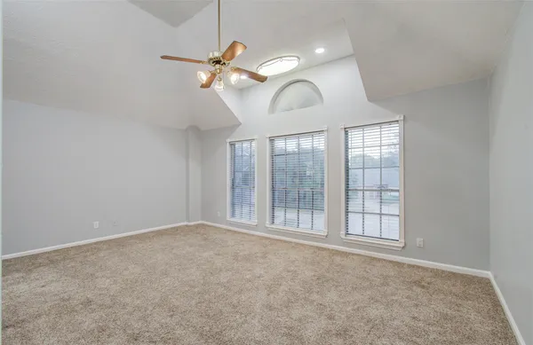 an empty room with windows and fan