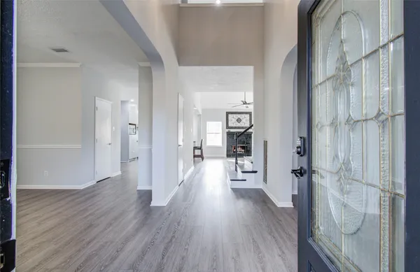 a view of a hallway with wooden floor and a bathroom
