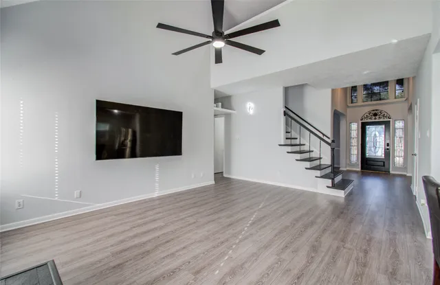 a view of a livingroom with wooden floor and a ceiling fan