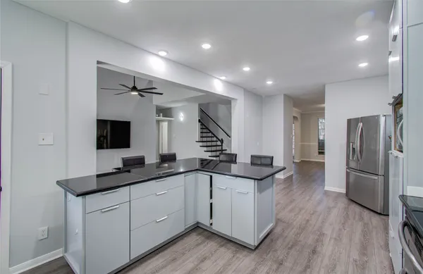 a kitchen with granite countertop a sink and refrigerator
