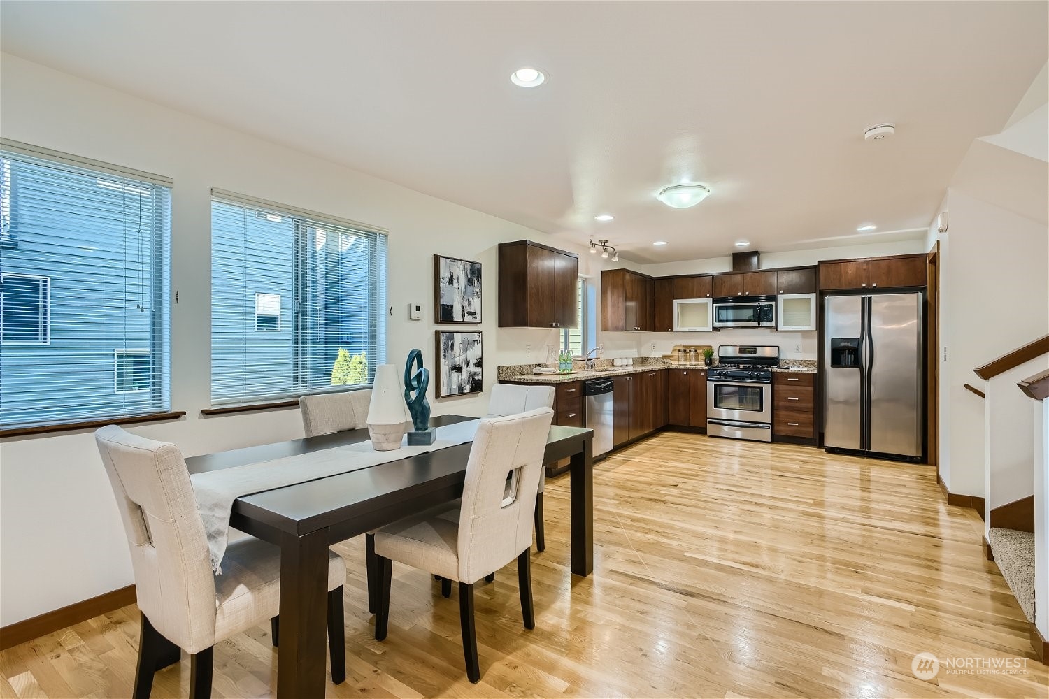 5935 California Avenue Southwest Seattle, WA 98136 - Photo 12 of 32 a kitchen with stainless steel appliances kitchen island granite countertop a dining table chairs sink refrigerator and cabinets