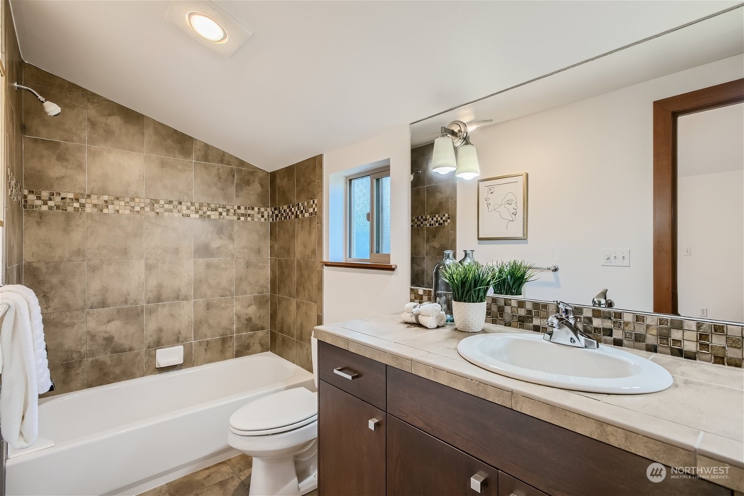 5935 California Avenue Southwest Seattle, WA 98136 - Photo 25 of 32 a bathroom with a granite countertop sink a toilet a mirror a bathtub and shower