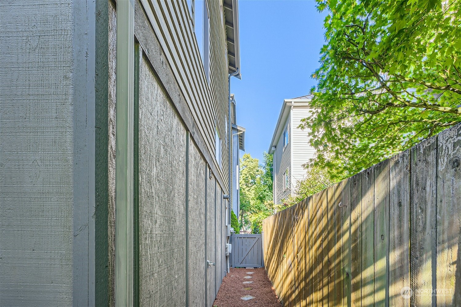 5935 California Avenue Southwest Seattle, WA 98136 - Photo 31 of 32 a view of a backyard with plants and wooden fence