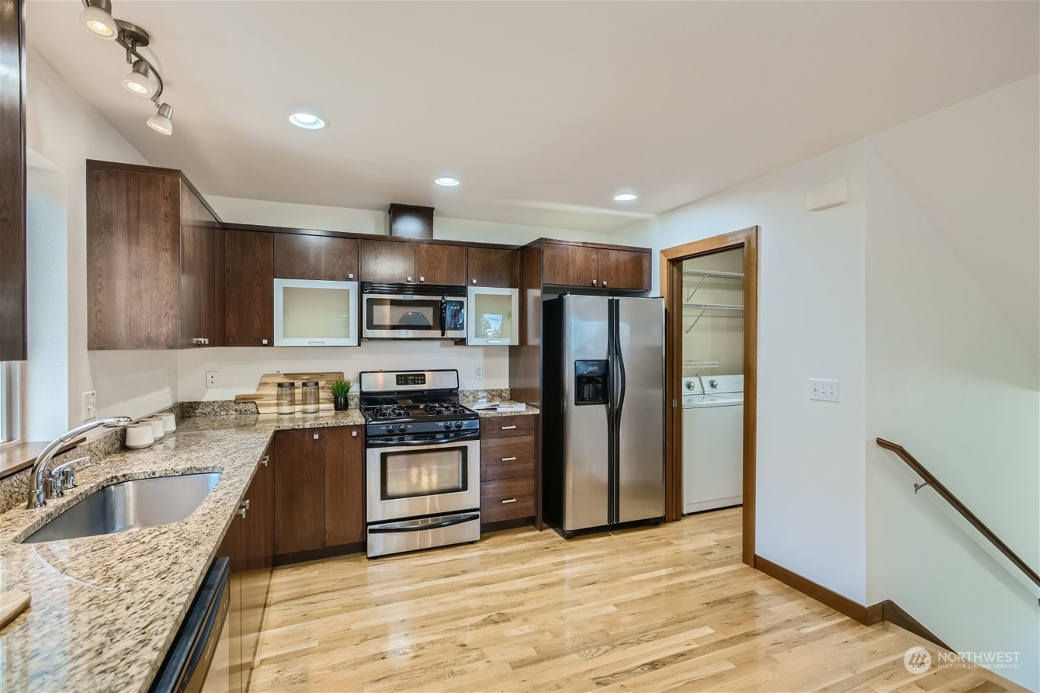 5935 California Avenue Southwest Seattle, WA 98136 - Photo 9 of 32 a kitchen with stainless steel appliances granite countertop a sink stove refrigerator and cabinets