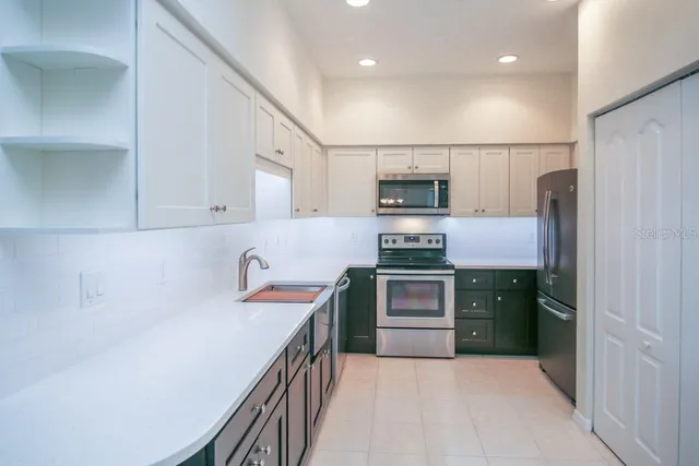 a kitchen with stainless steel appliances a refrigerator sink and cabinets