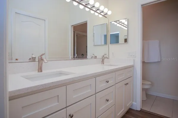 a bathroom with a sink a toilet and mirror