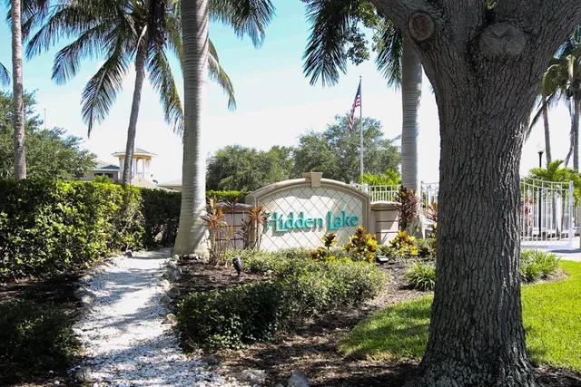 a front view of a house with a yard and palm trees