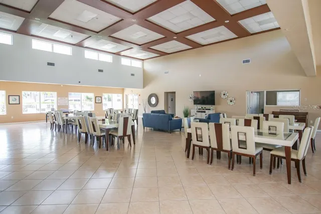 a group of people sitting in a room with kitchen view