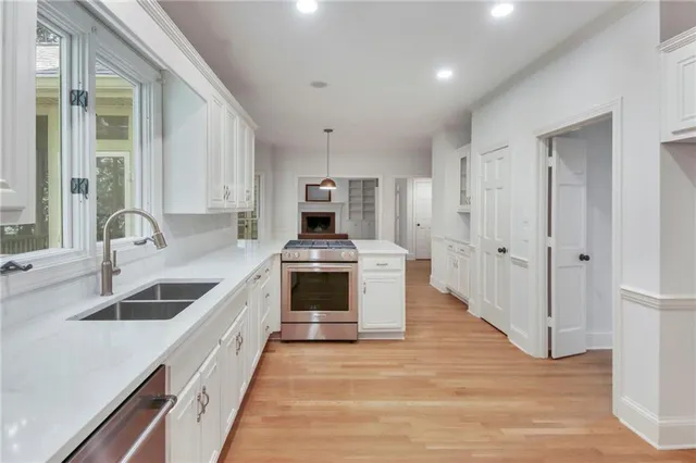 a kitchen with granite countertop a sink stove and refrigerator