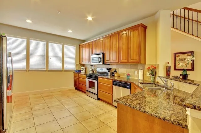 a large kitchen with kitchen island a large window in it