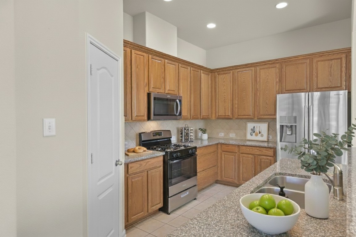 39 Butternut Grove Place Tomball, TX 77375 - Photo 10 of 29 a kitchen with stainless steel appliances a sink a stove a microwave a refrigerator and cabinets