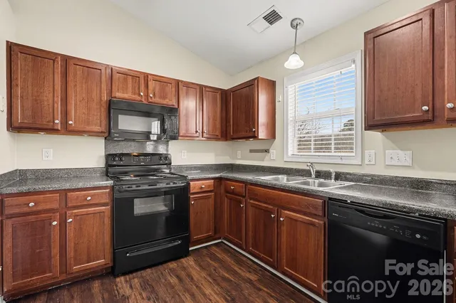 a kitchen with stainless steel appliances granite countertop a sink stove and cabinets