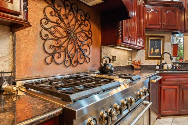 a kitchen with stainless steel appliances granite countertop wooden cabinets a stove top oven a sink and dishwasher