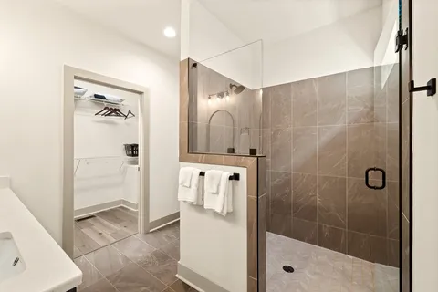 a bathroom with a shower a sink and a mirror