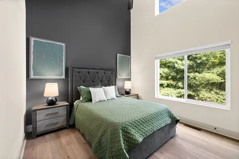 a large bed sitting in a bedroom next to a window