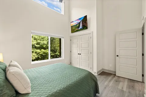 a bedroom with a bed and a wooden floor