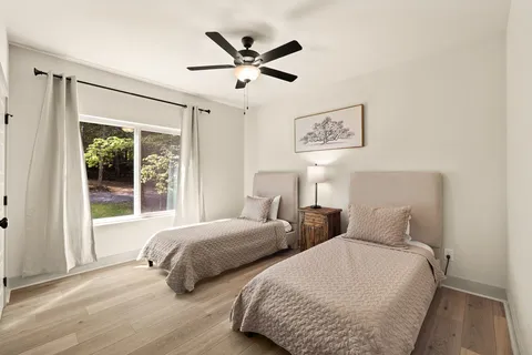 a bedroom with two beds and a large window
