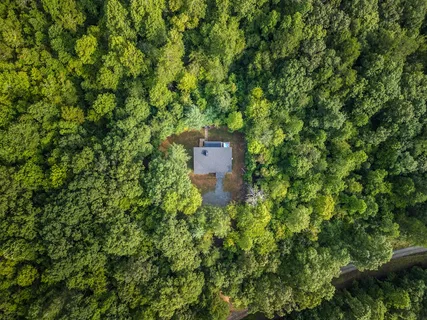 an aerial view of a house with a yard and large trees