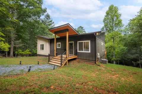 a front view of a house with a garden and yard