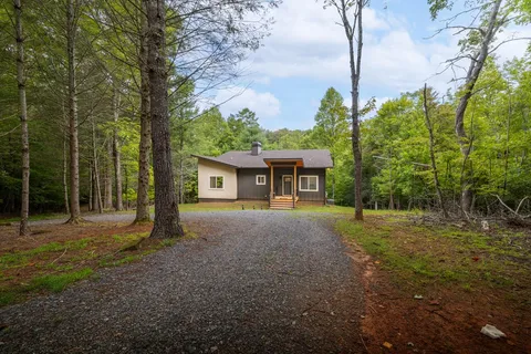 a view of a house with backyard and a tree