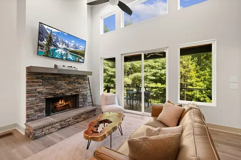 a living room with furniture a fireplace and a large window