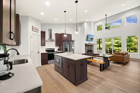 a kitchen with kitchen island a white counter top space a sink appliances and a counter top space