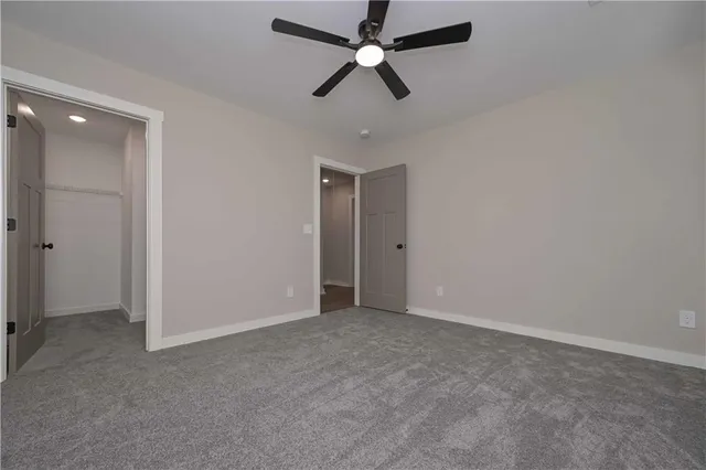 an empty room with closet and windows