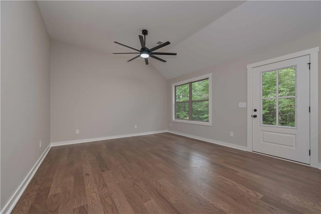15 Weaver Street Buchanan, GA 30113 - Photo 9 of 22 an empty room with wooden floor fan and windows