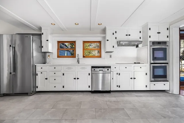 a view of a kitchen with white cabinets