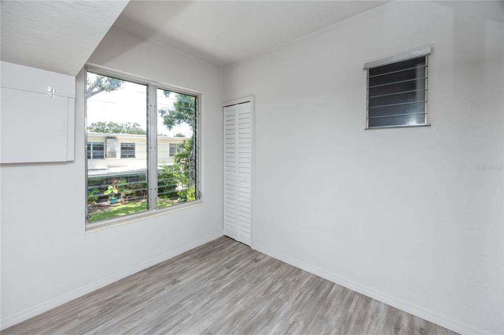 4152 55th Way North, Unit 1028 Kenneth City, FL 33709 - Photo 24 of 46 an empty room with wooden floor and windows