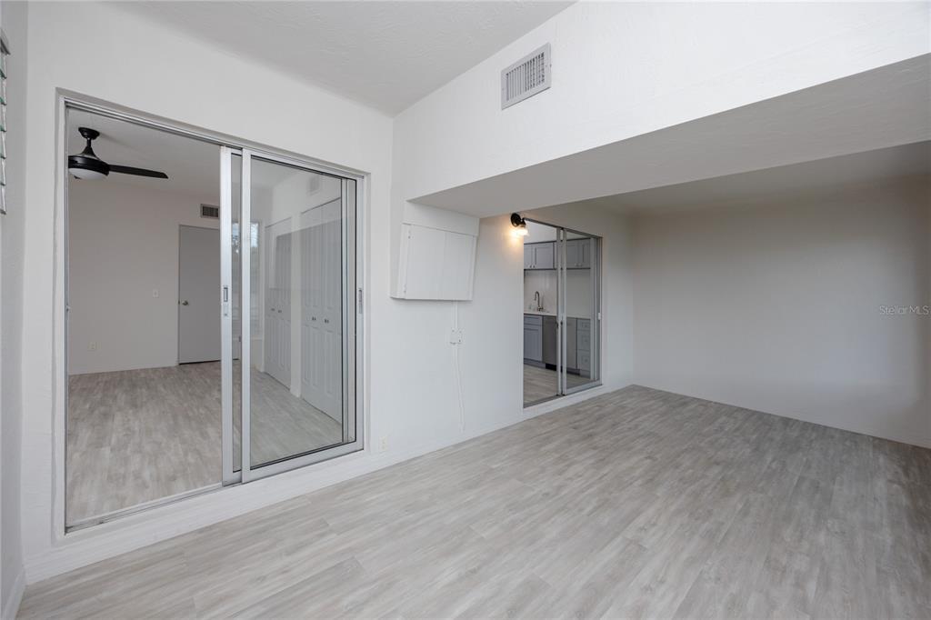 4152 55th Way North, Unit 1028 Kenneth City, FL 33709 - Photo 26 of 46 a view of an empty room with wooden floor and a window