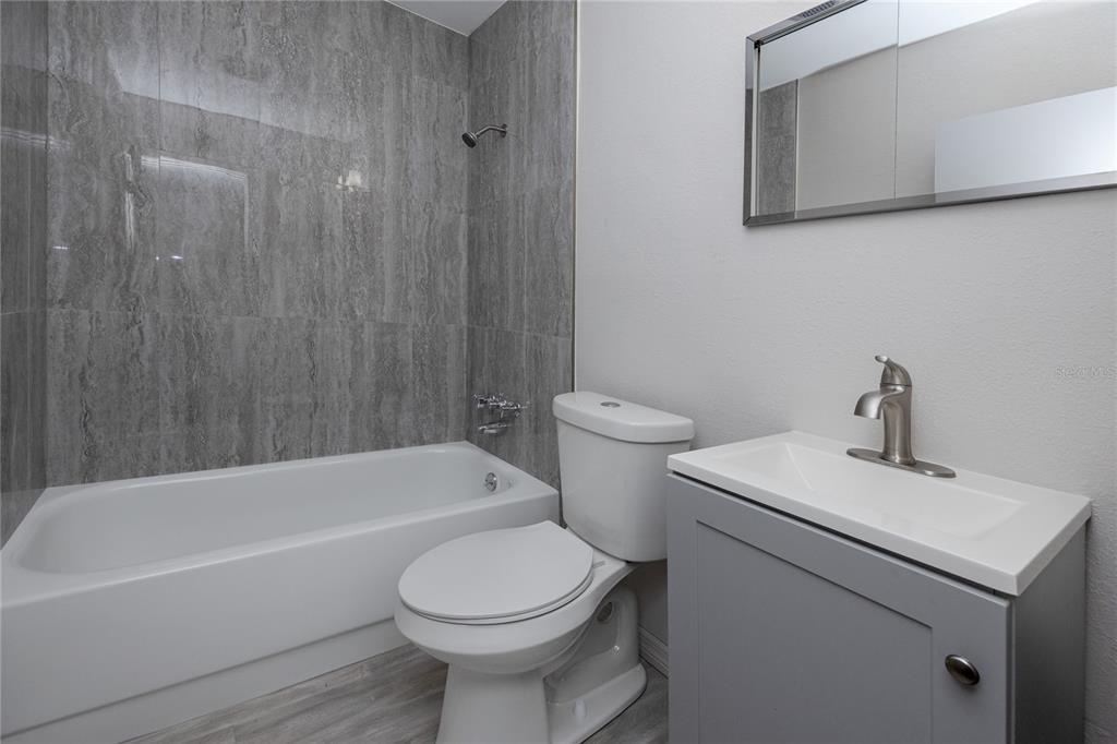 4152 55th Way North, Unit 1028 Kenneth City, FL 33709 - Photo 36 of 46 a bathroom with a sink a toilet and bathtub