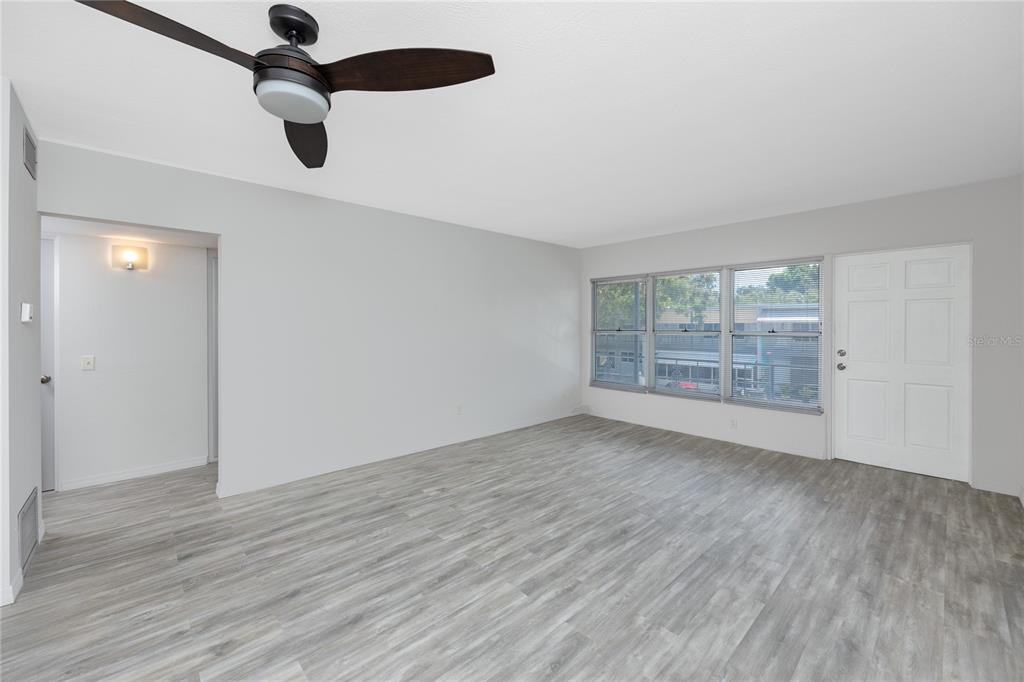 4152 55th Way North, Unit 1028 Kenneth City, FL 33709 - Photo 8 of 46 wooden floor in an empty room with a window