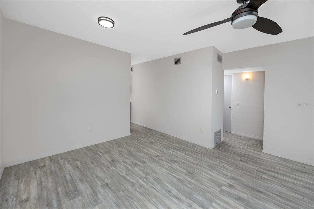 4152 55th Way North, Unit 1028 Kenneth City, FL 33709 - Photo 10 of 46 a view of an empty room with wooden floor
