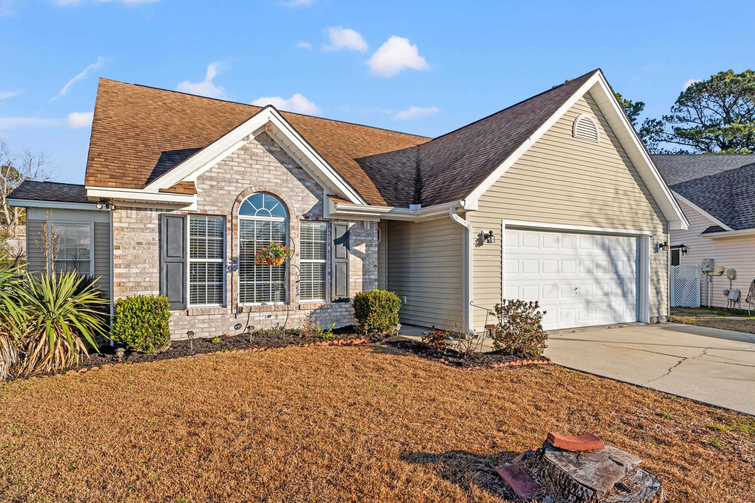 539 Drake Lane Surfside Beach, SC 29575 - Photo 1 of 38 View of front of home with concrete driveway, brick siding, a shingled roof, a garage, and a front lawn