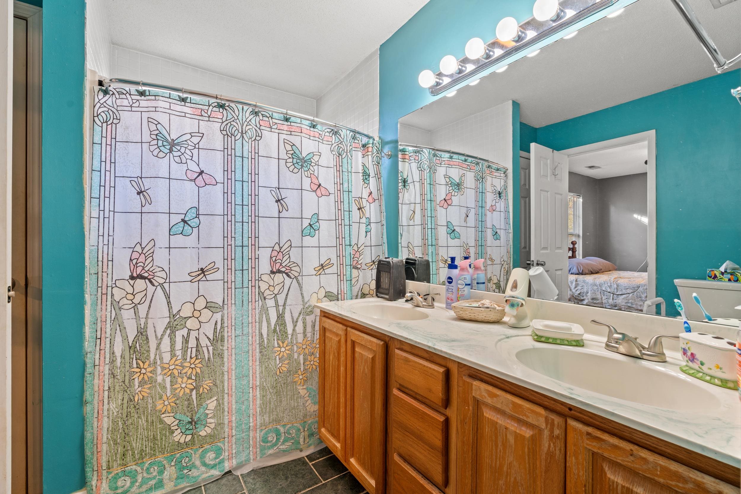 539 Drake Lane Surfside Beach, SC 29575 - Photo 14 of 38 Full bathroom featuring connected bathroom, double vanity, a shower with shower curtain, and dark tile patterned flooring