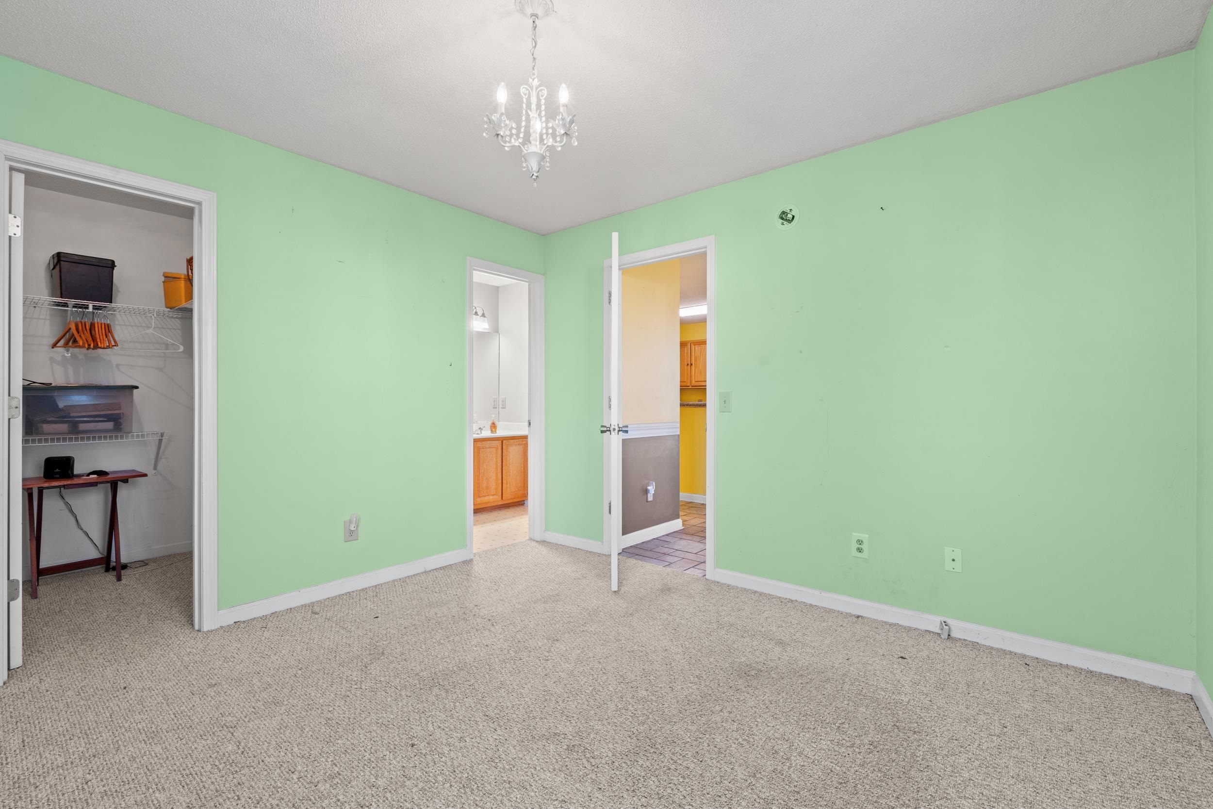 539 Drake Lane Surfside Beach, SC 29575 - Photo 16 of 38 Unfurnished bedroom featuring a walk in closet, a chandelier, and light carpet