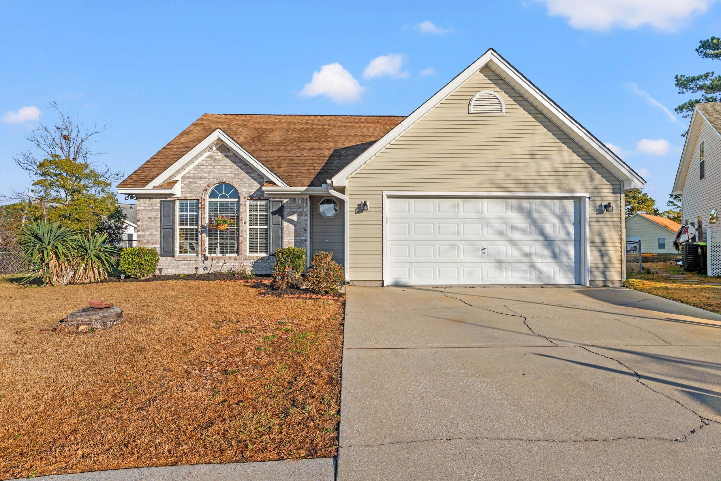 539 Drake Lane Surfside Beach, SC 29575 - Photo 2 of 38 View of front facade featuring concrete driveway, brick siding, roof with shingles, a front yard, and an attached garage