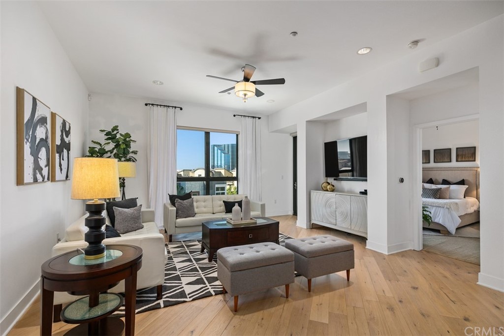 a living room with furniture a flat screen tv and kitchen view