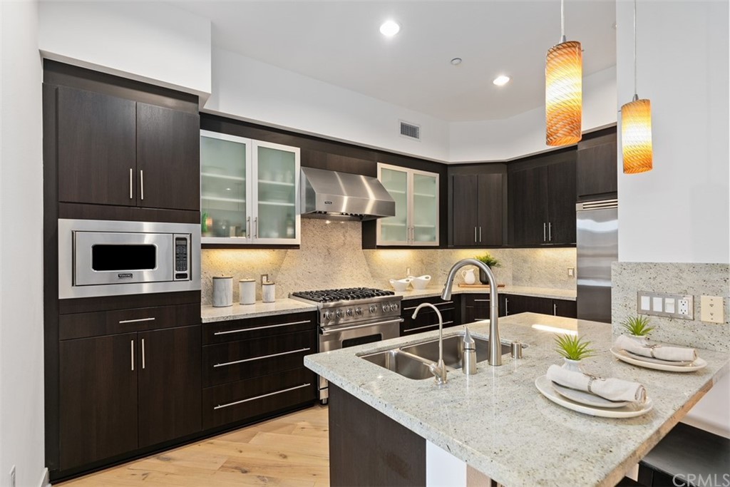402 Rockefeller, Unit 406 Irvine, CA 92612 - Photo 4 of 35 a kitchen with a sink a stove and chairs